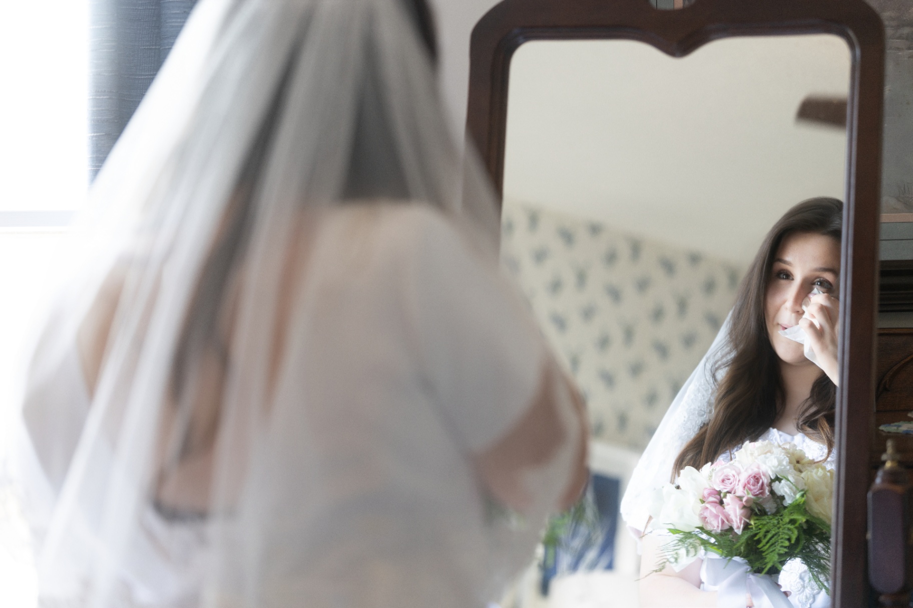 Emotional bride in the mirror with bouquet at L & D Farms