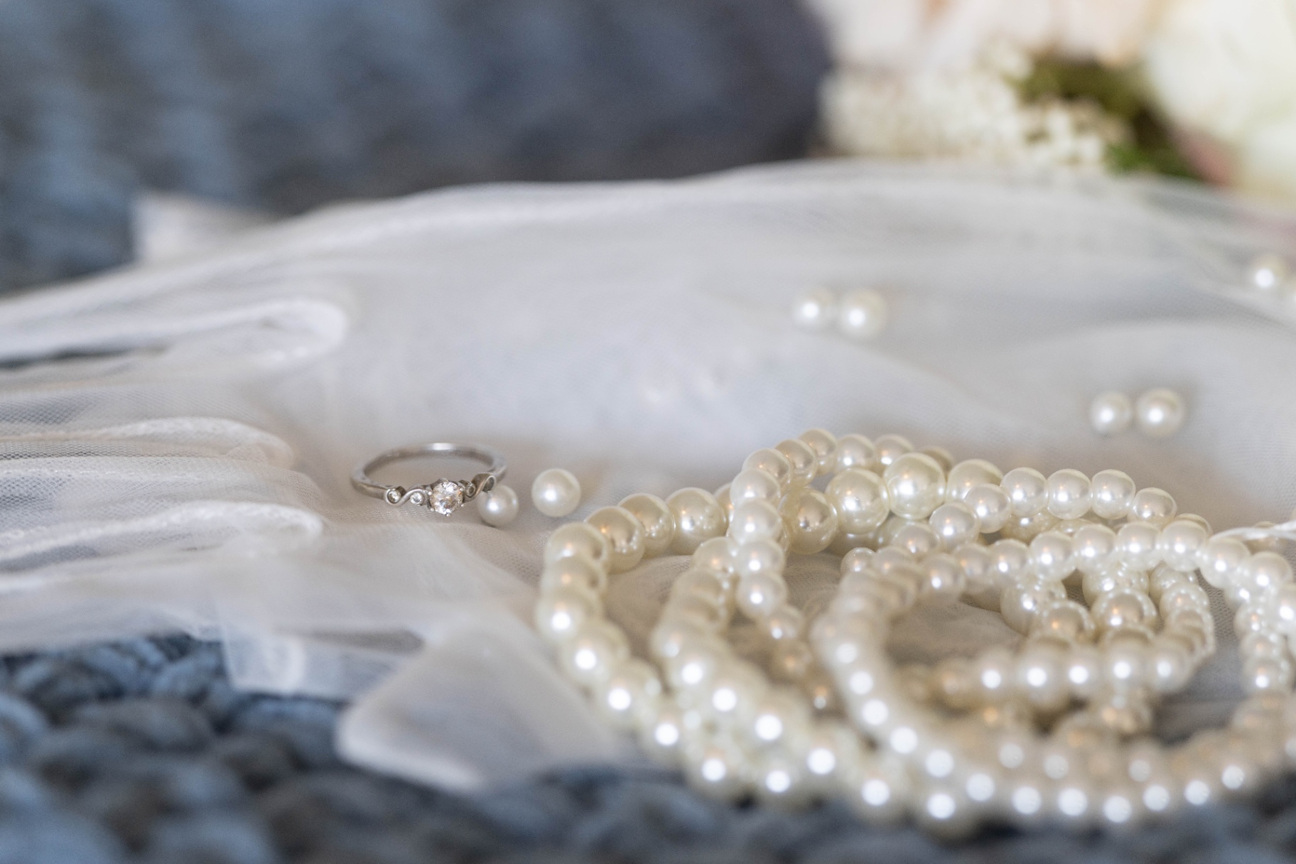 Wedding ring and pearls arranged on bridal gloves at L & D Farms