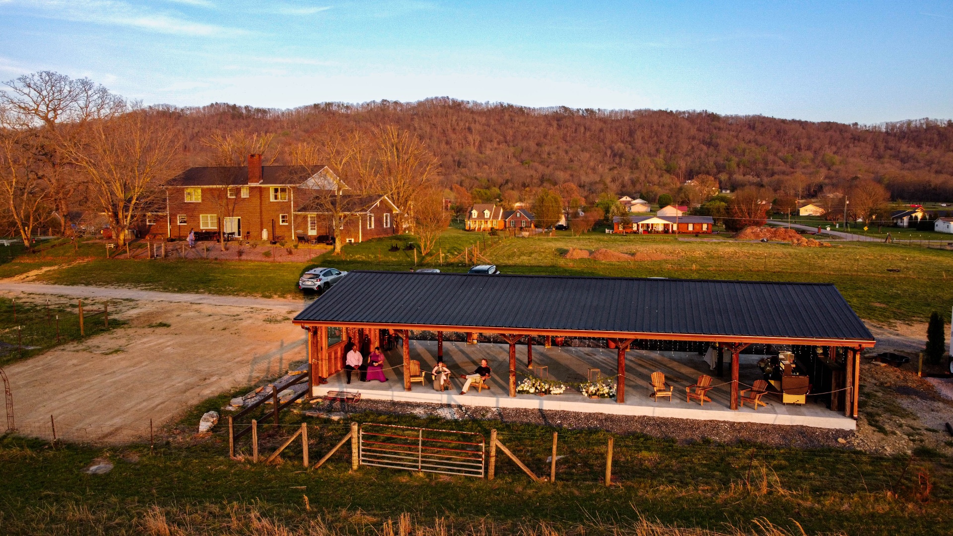 Pavilion event space with farmhouse and mountains beyond at L & D Farms