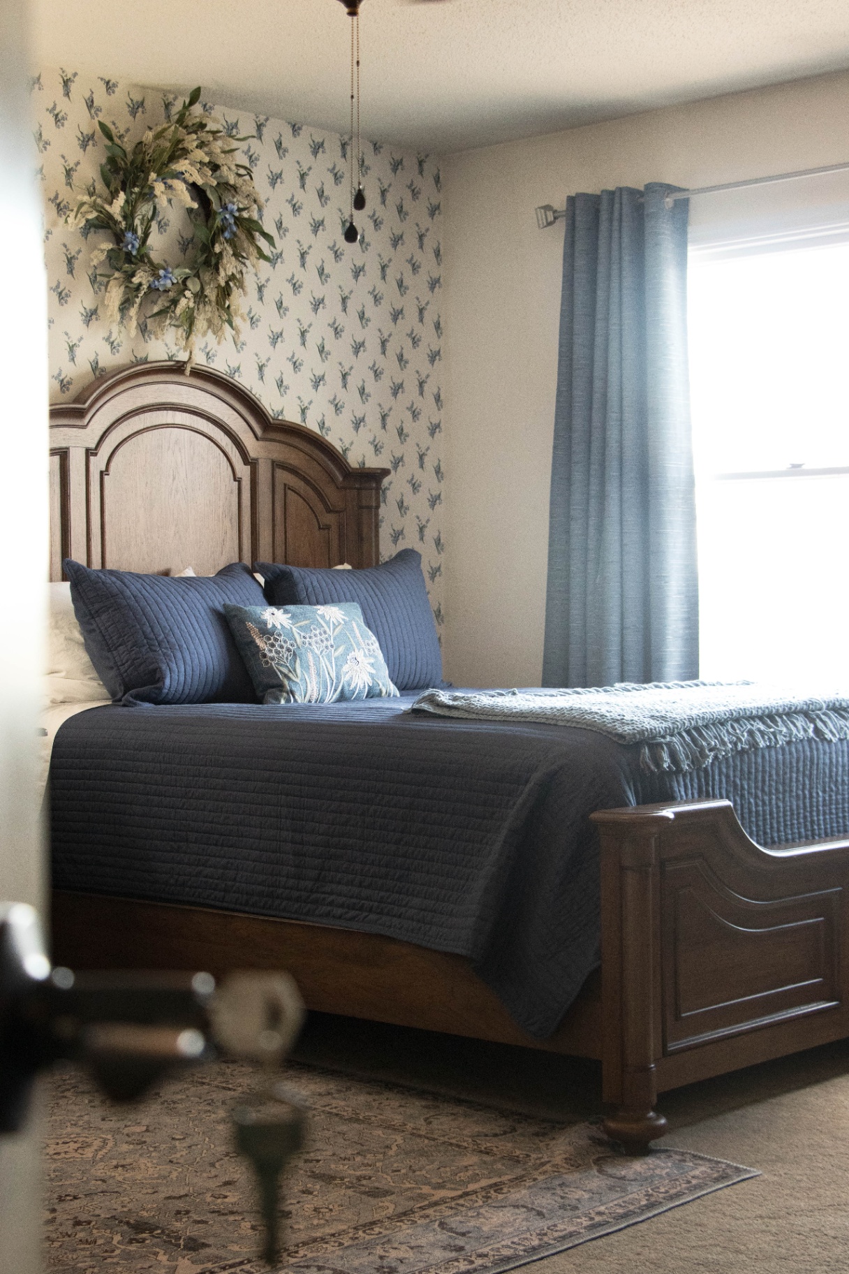 Guest bedroom with blue florals and antique headboard at L & D Farms