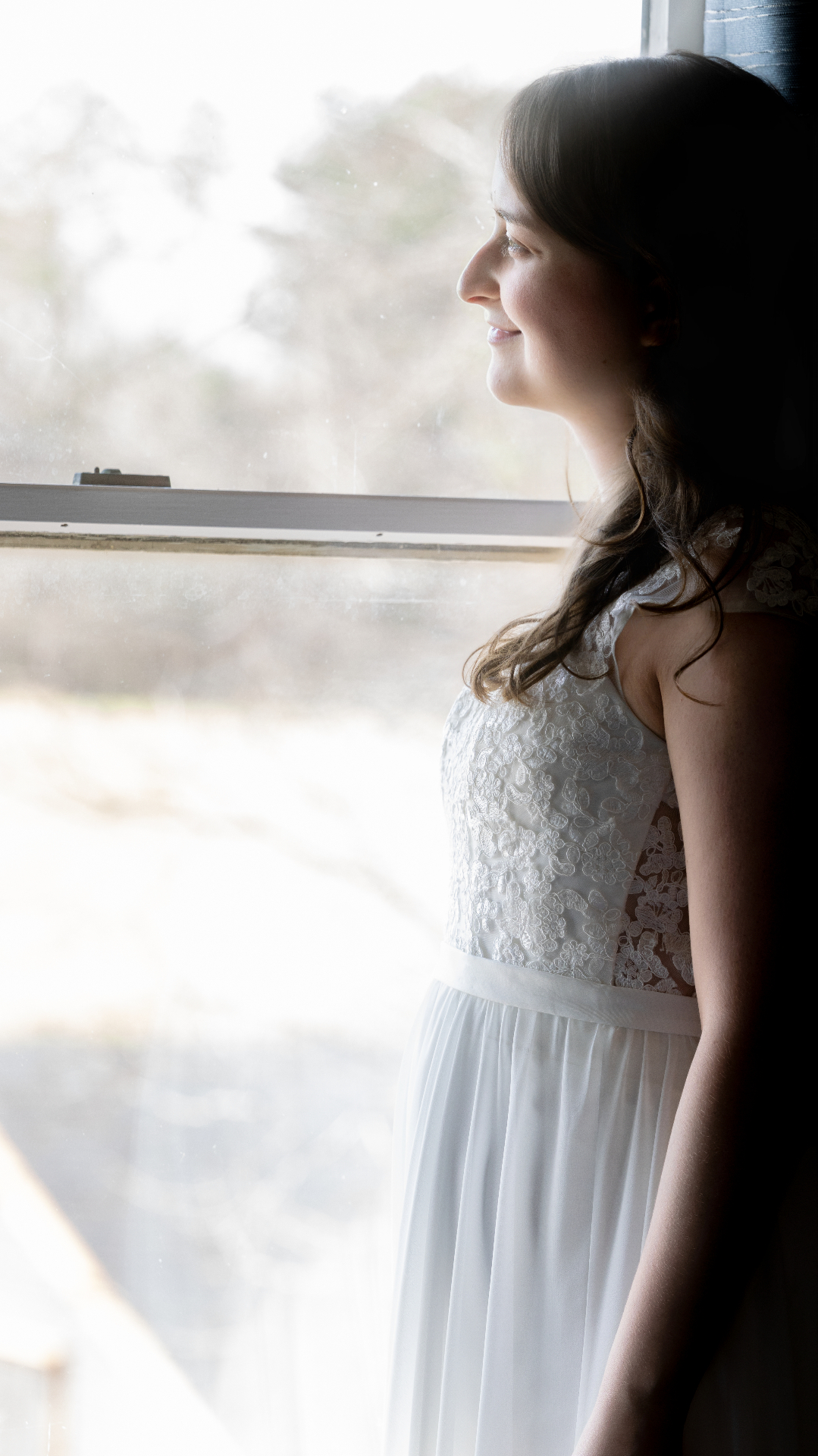 Bride by the window in soft morning light at L & D Farms