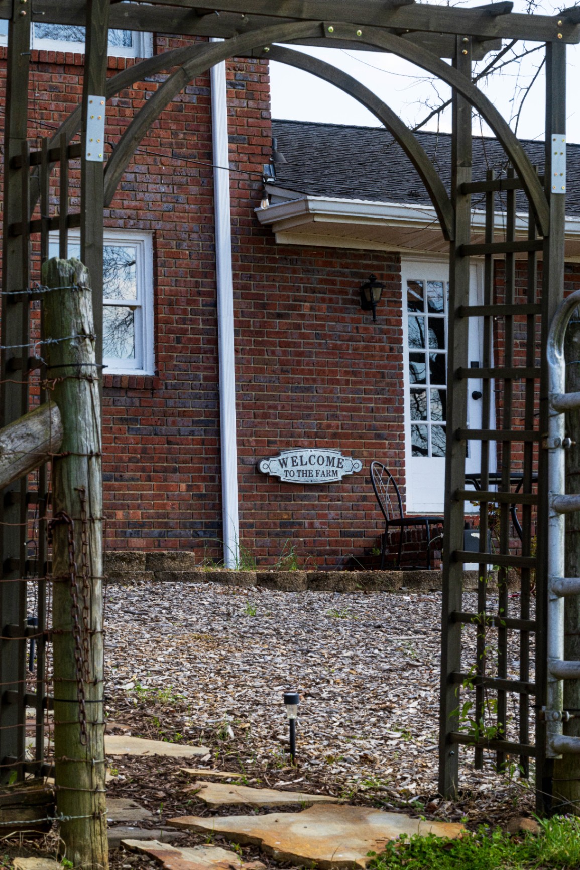 Farmhouse entry framed by the garden arbor at L & D Farms