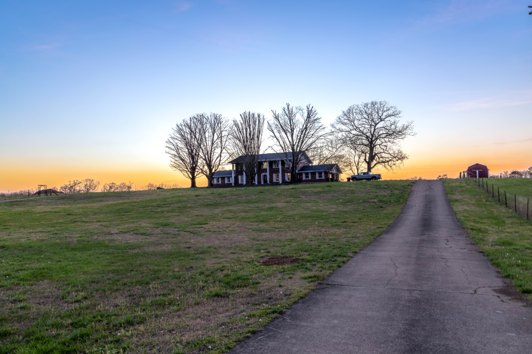 Sunset view of the farmhouse from the driveway at L & D Farms